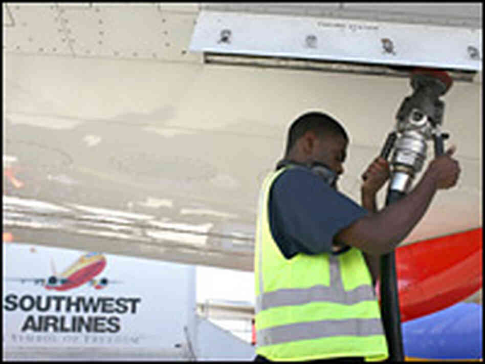 An airline worker removes a fuel line from a Southwest Airlines plane.