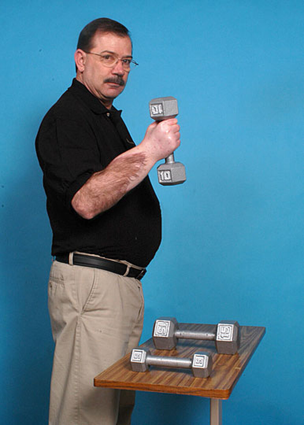 Transplant patient David Savage holds a weight.