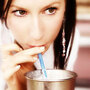 A woman savors a milkshake.