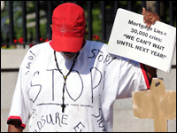 Deborah Williams holds a sign and a homemade key