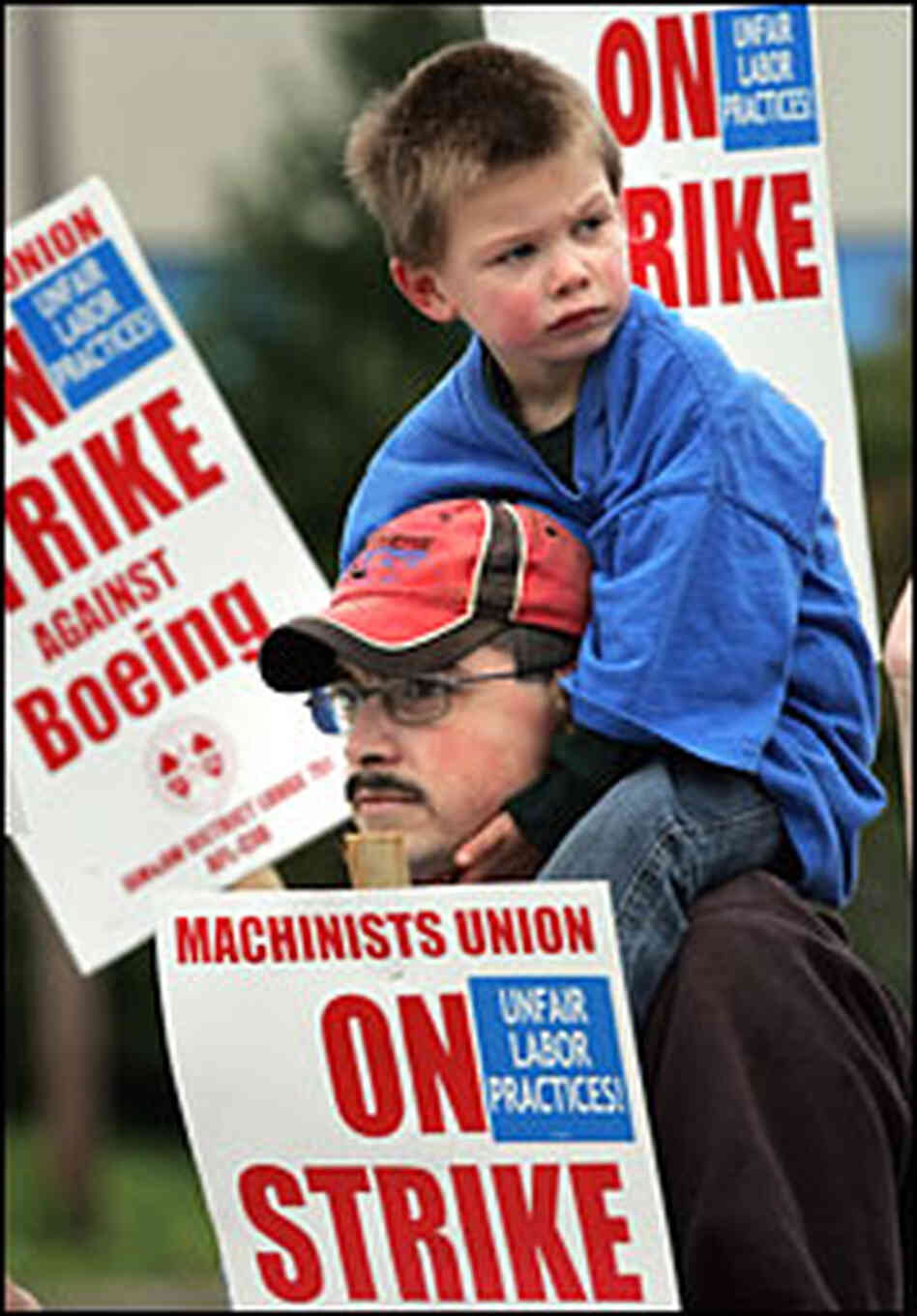 Boeing machinist Scott Green, with his son Joshua, 3, walks the picket line on Saturday. Boeing machinist Scott Green, with his son Joshua, 3, walks the picket line on Saturday.
