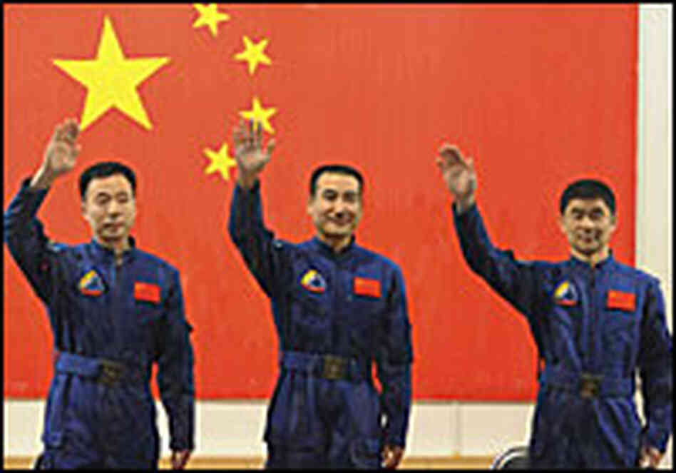 Taikonauts (from left) Jing Haipeng, Zhai Zhigang and Liu Boming wave during a news conference.