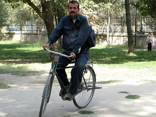 Afghan bicycle messenger riding a bike