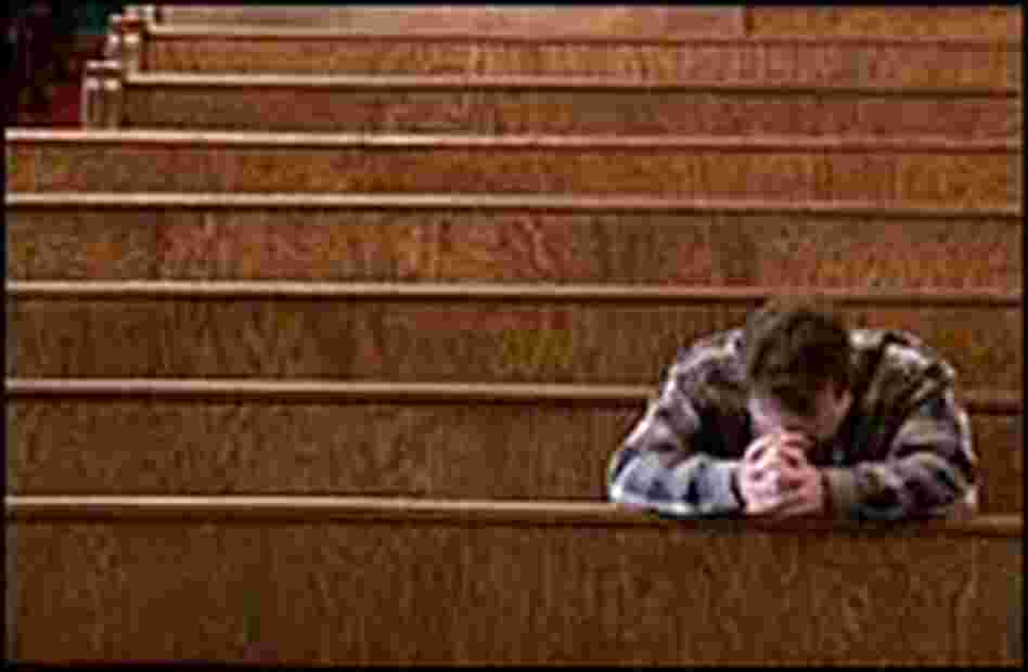 A man prays in a church. A man prays in a church.