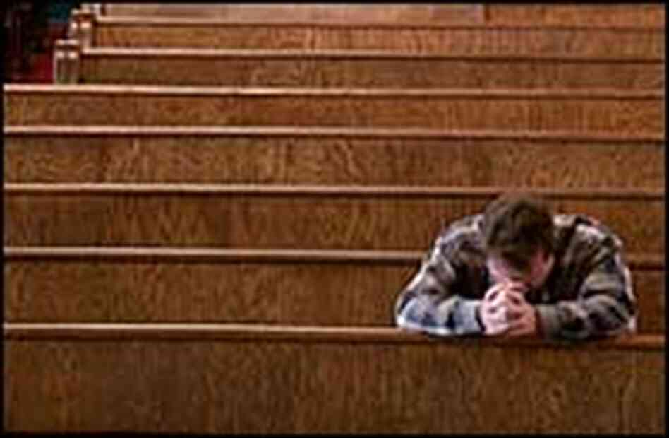 A man prays in a church. A man prays in a church.