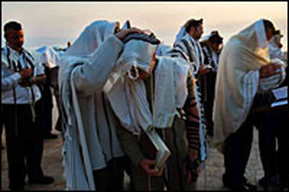 Religious Jews cover themselves and their sons to receive the priestly blessing in Israel Wednesday.