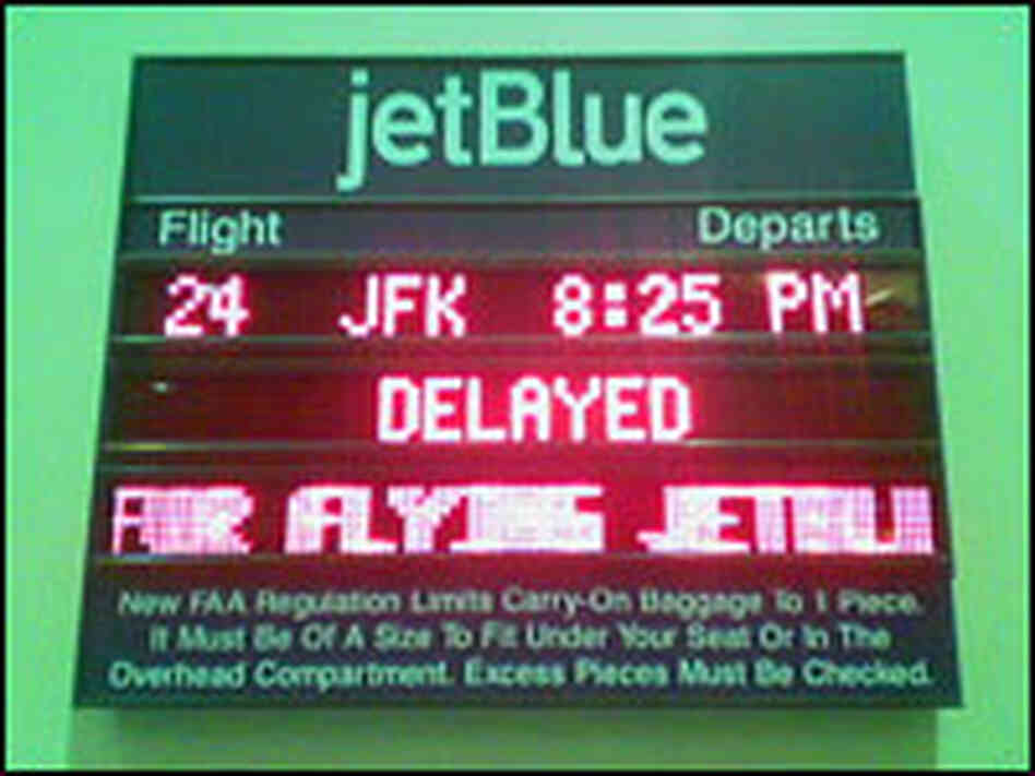 A board showing a delayed Jet Blue flight. A board showing a delayed Jet Blue flight.