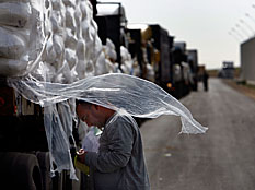 A truck driver certifies his load of U.N. food aid at the Kerem Shalom border crossing between Israel and the Gaza Strip Thursday, Jan. 8, 2009.  The United Nations says it is halting all aid deliveries to the besieged Gaza Strip. Credit: David Gilkey/NPR