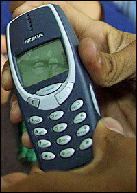 Afghan men learn how to use a cell phone at Kabul's Post Office in Afghanistan, April 23, 2002 . An Afghan-U.S. telecommunication joint venture set up mobile phone capabilities in the Afghan capital and began expanding out to other cities and towns in 2002.