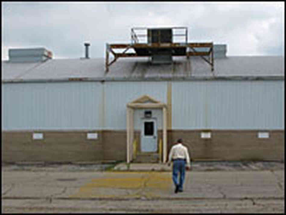 Gary McKinney, a city official for Anderson, Ind., walks toward an abandoned GM plant.