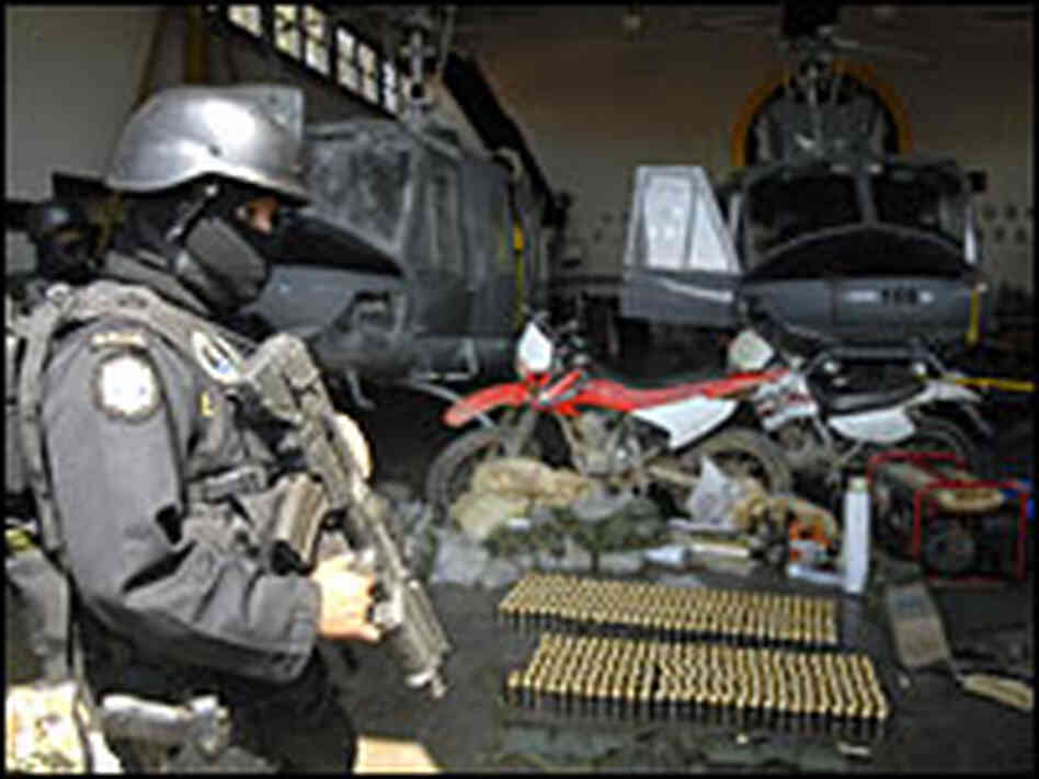 Guatemalan policeman guards arms confiscated from camp of alleged Mexican drug traffickers.