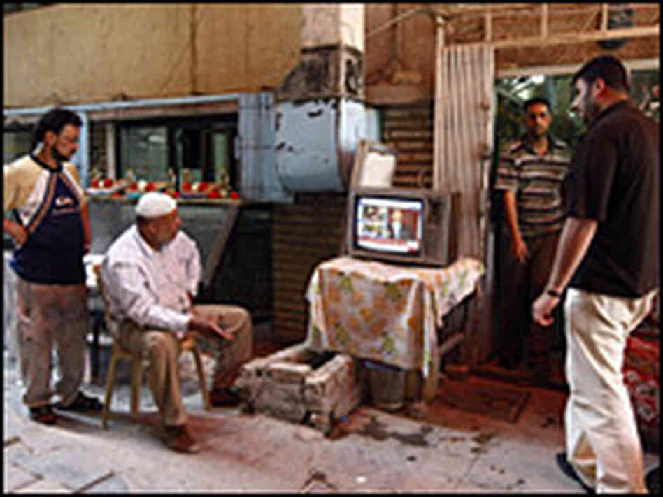 Iraqi men in Baghdad watch a live broadcast on satellite TV of President Obama's speech in Cairo
