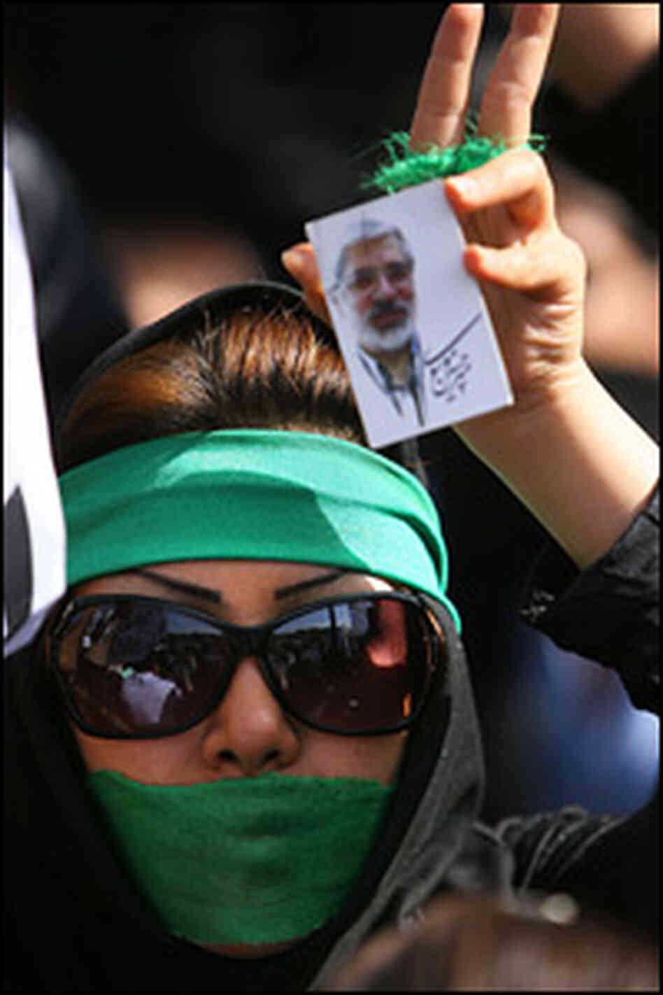 A supporter of opposition leader Mir Hossein Mousavi listens to his speech in Tehran on Thursday.
