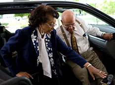 Joyce Peterson helps her husband out of the van at the hospital where he takes his driving lessons. Credit: Katie Hayes/NPR