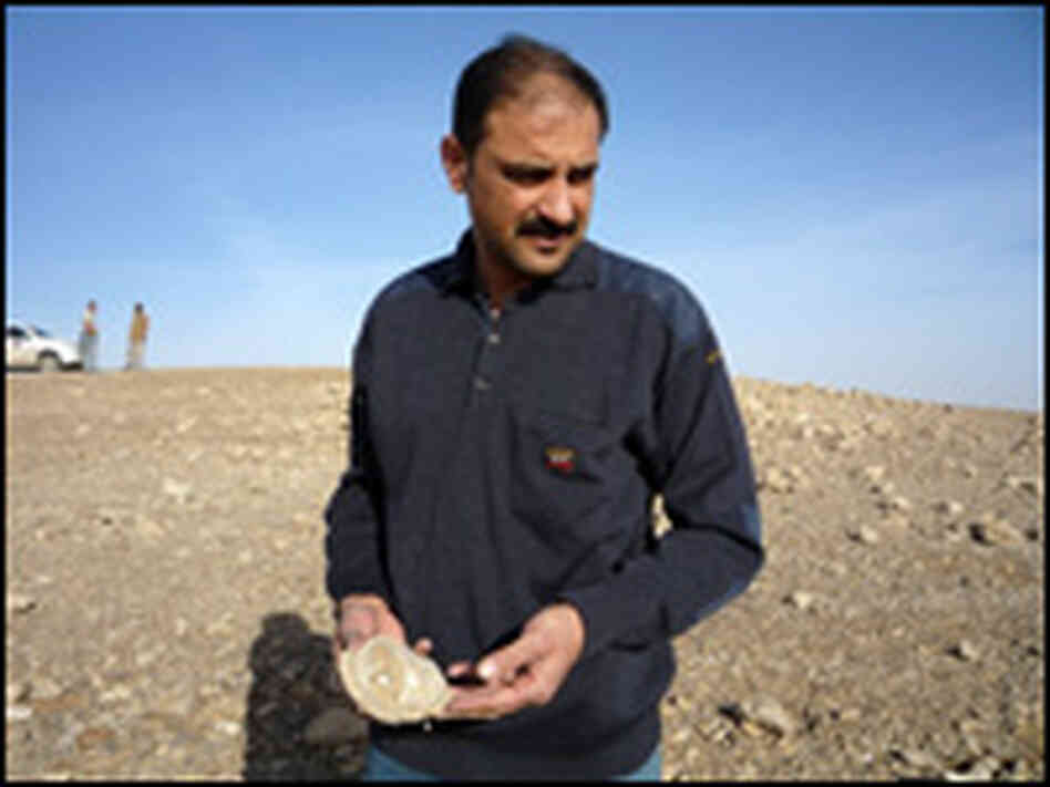 Dr. Yousif Jasir Muhammed picks up a shard of pottery at a newly discovered Roman-era site