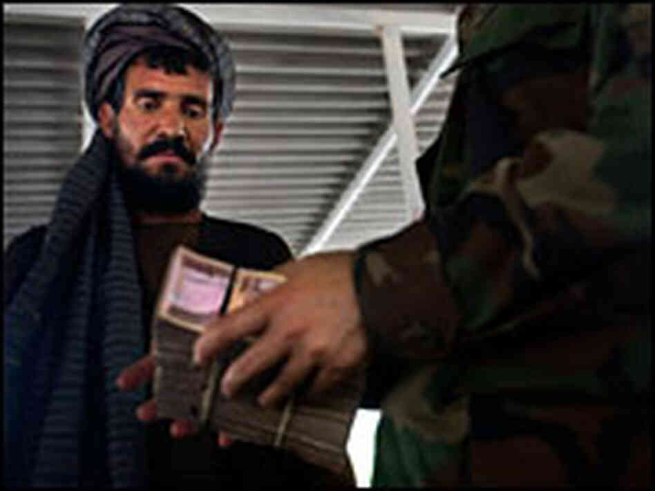 Muhammad Hussein receives money during a reparations ceremony for civilian casualties