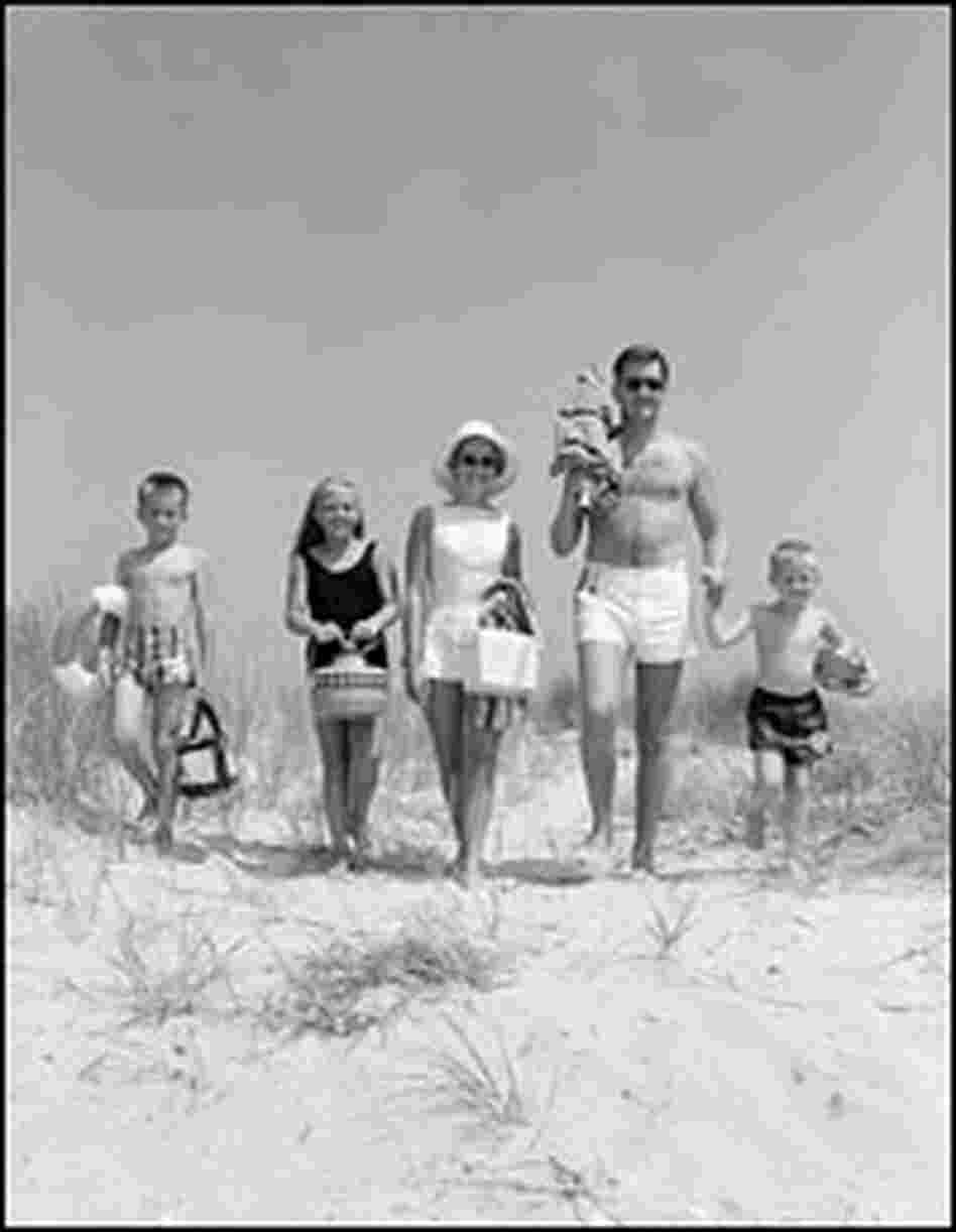 An American family of five walks toward the beach in bathing suits, circa 1960s.