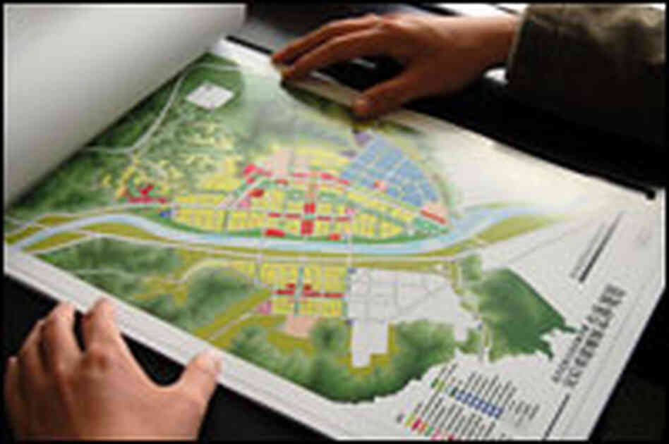 He Xian, the deputy chief of Beichuan county, reviews the master plan for rebuilding the city.