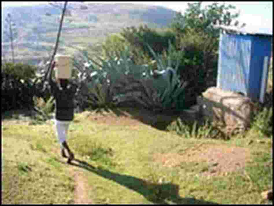 Itumeleng Ntjana carries a bucket of water on her head.