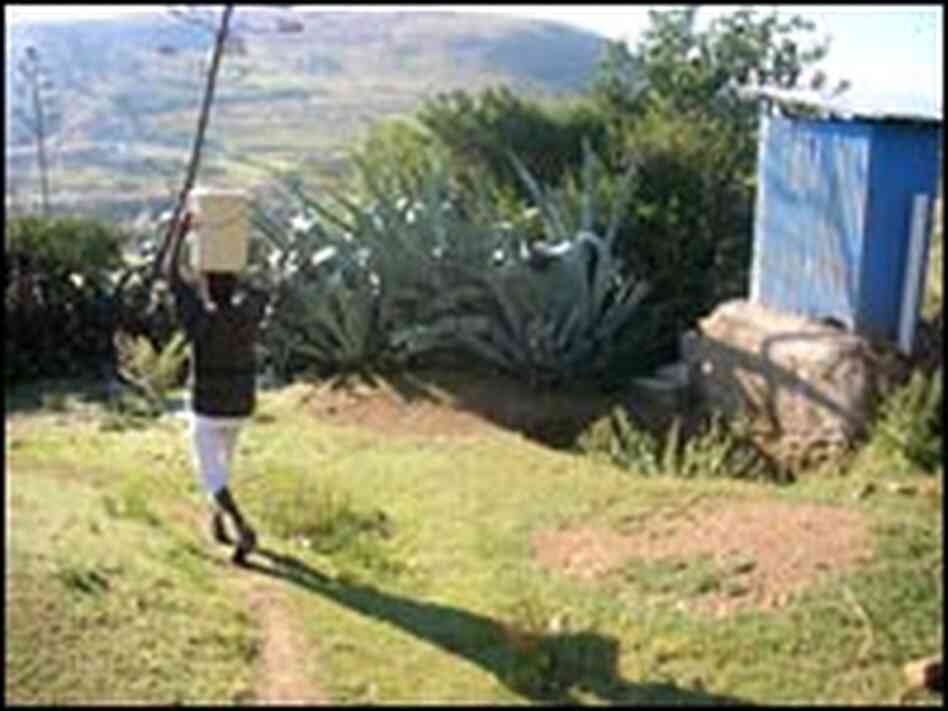 Itumeleng Ntjana carries a bucket of water on her head.