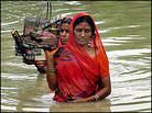 Bangladeshi women make their way through flood water at Dhakuria in Sirajgonj district. Bangladeshi women make their way through flood water at Dhakuria in Sirajgonj district.