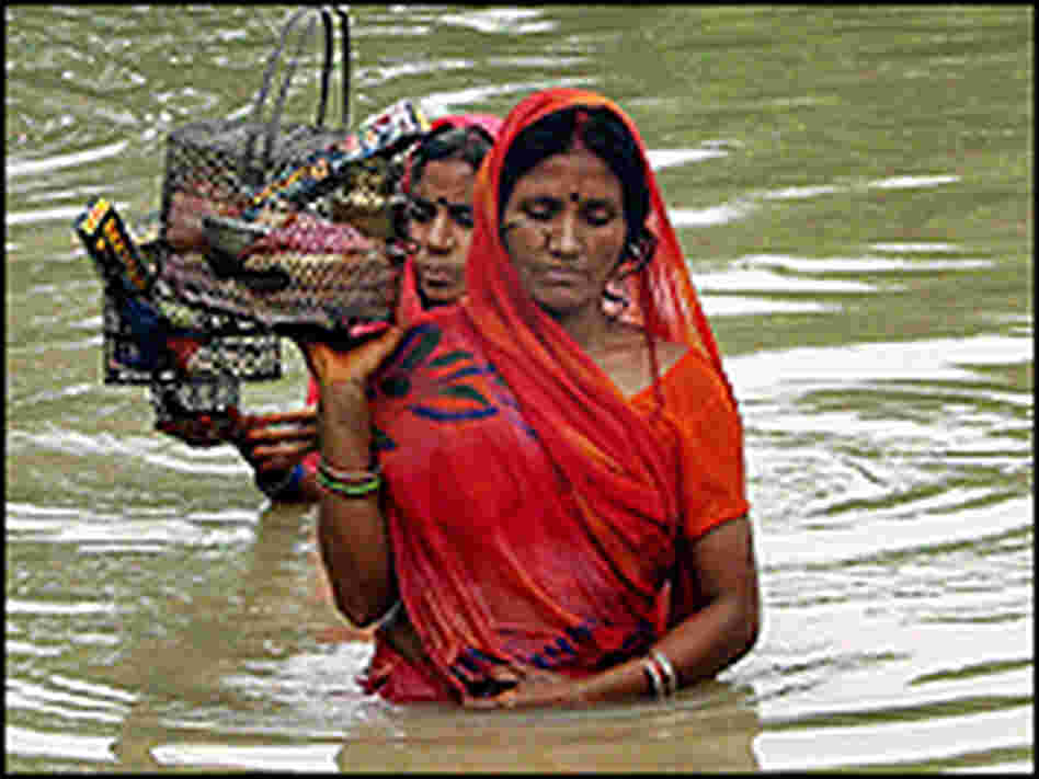 Bangladeshi women make their way through flood water at Dhakuria in Sirajgonj district. Bangladeshi women make their way through flood water at Dhakuria in Sirajgonj district.