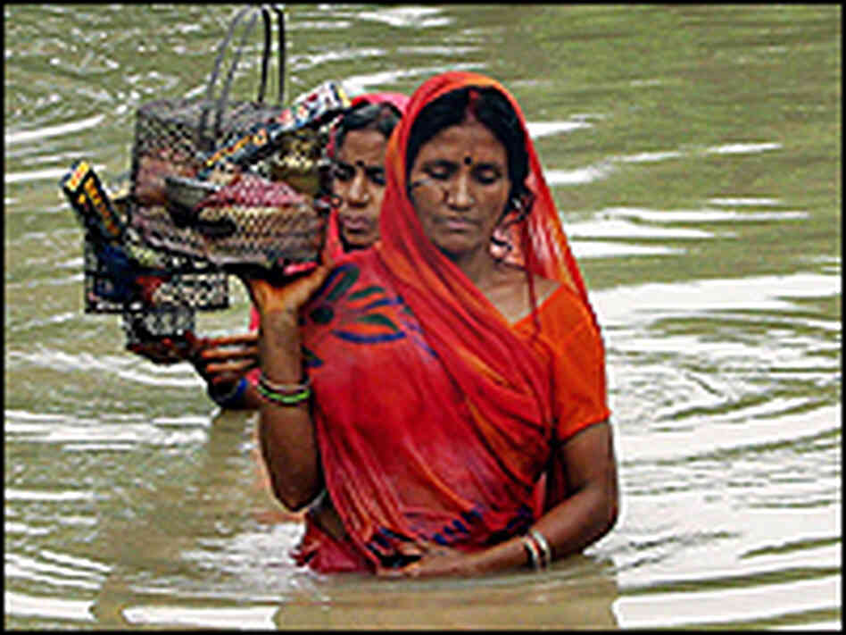 Bangladeshi women make their way through flood water at Dhakuria in Sirajgonj district. Bangladeshi women make their way through flood water at Dhakuria in Sirajgonj district.