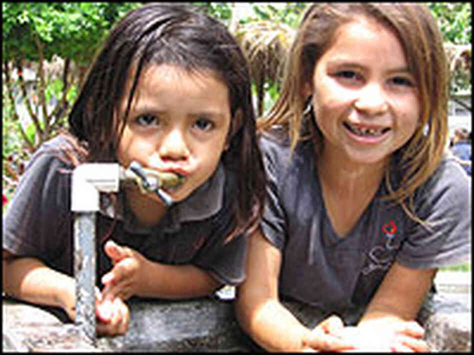 Two girls drink from a deep well recently dug at an elementary school in El Salvador. Two girls drink from a deep well recently dug at an elementary school in El Salvador.