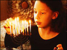 Girl lights menorah. Girl lights menorah.