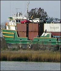 Shipping containers tossed ashore by Katrina still have cars lashed onto them.