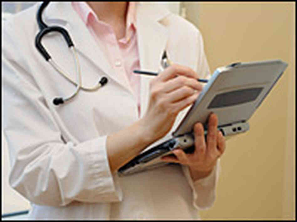 A doctor writes notes on a laptop. A doctor writes notes on a laptop.