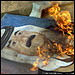 Painting of Saddam Hussein burns.