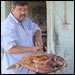 Iraqi man holds out finished platter of mazgouf.