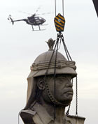 A giant bronze bust of Saddam Hussein is removed from the former dictator's Republican Palace.