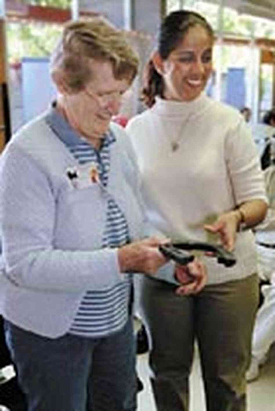 Aide helps an elderly participant at John C. Lincoln Hospital's adult day care center play horseshoe Aide helps an elderly participant at John C. Lincoln Hospital's adult day care center play horseshoe