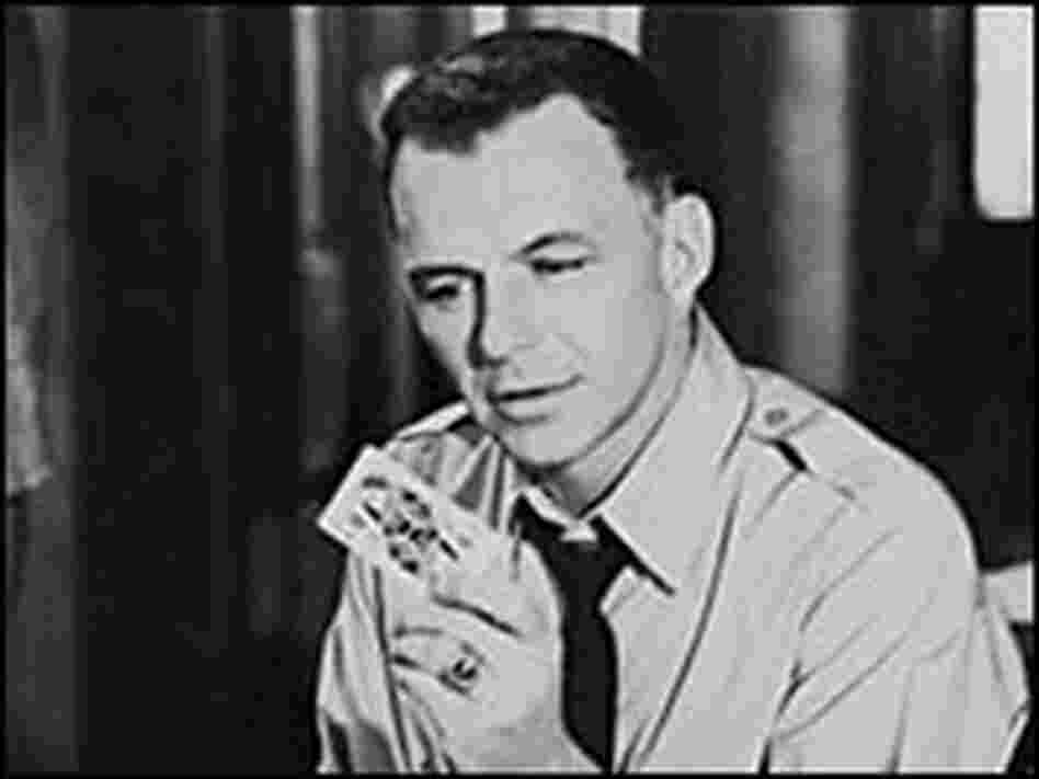 Frank Sinatra holds a playing card. Frank Sinatra holds a playing card.