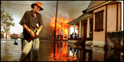 A resident walks past a burning house fire in the Seventh Ward Sept. 6, 2005 in New Orleans.