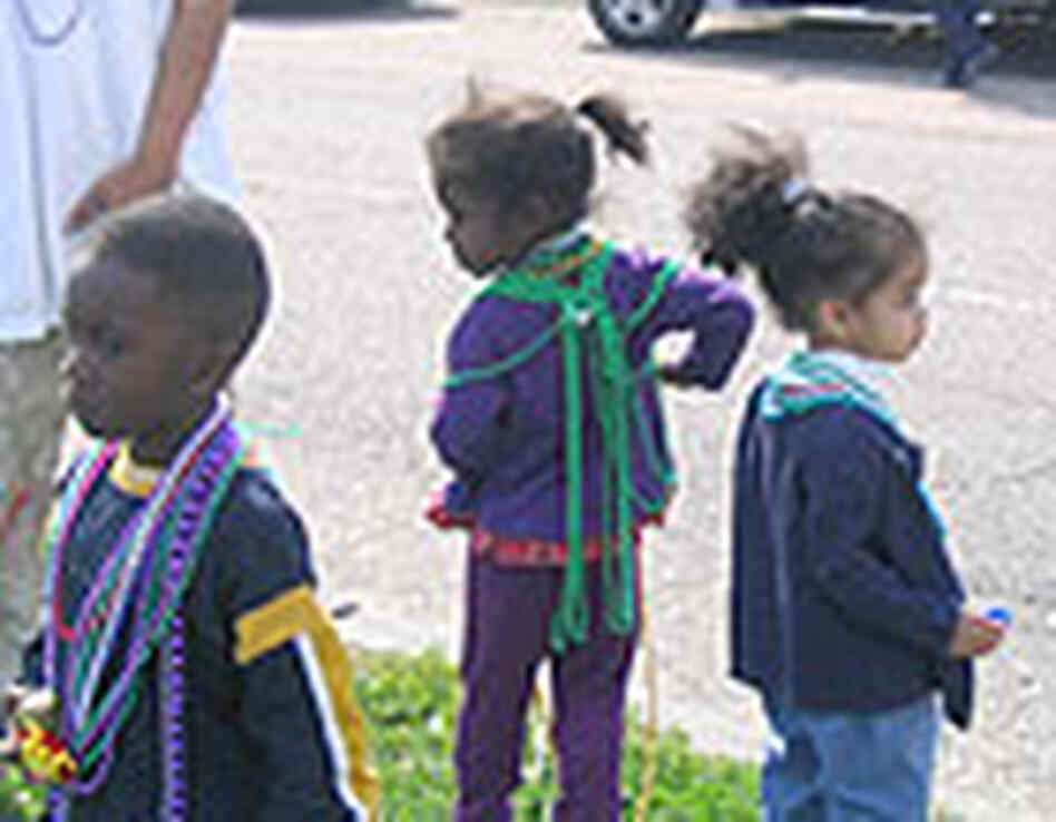 Children catch their share of bead necklaces at a neighborhood elementary school parade. Children catch their share of bead necklaces at a neighborhood elementary school parade.