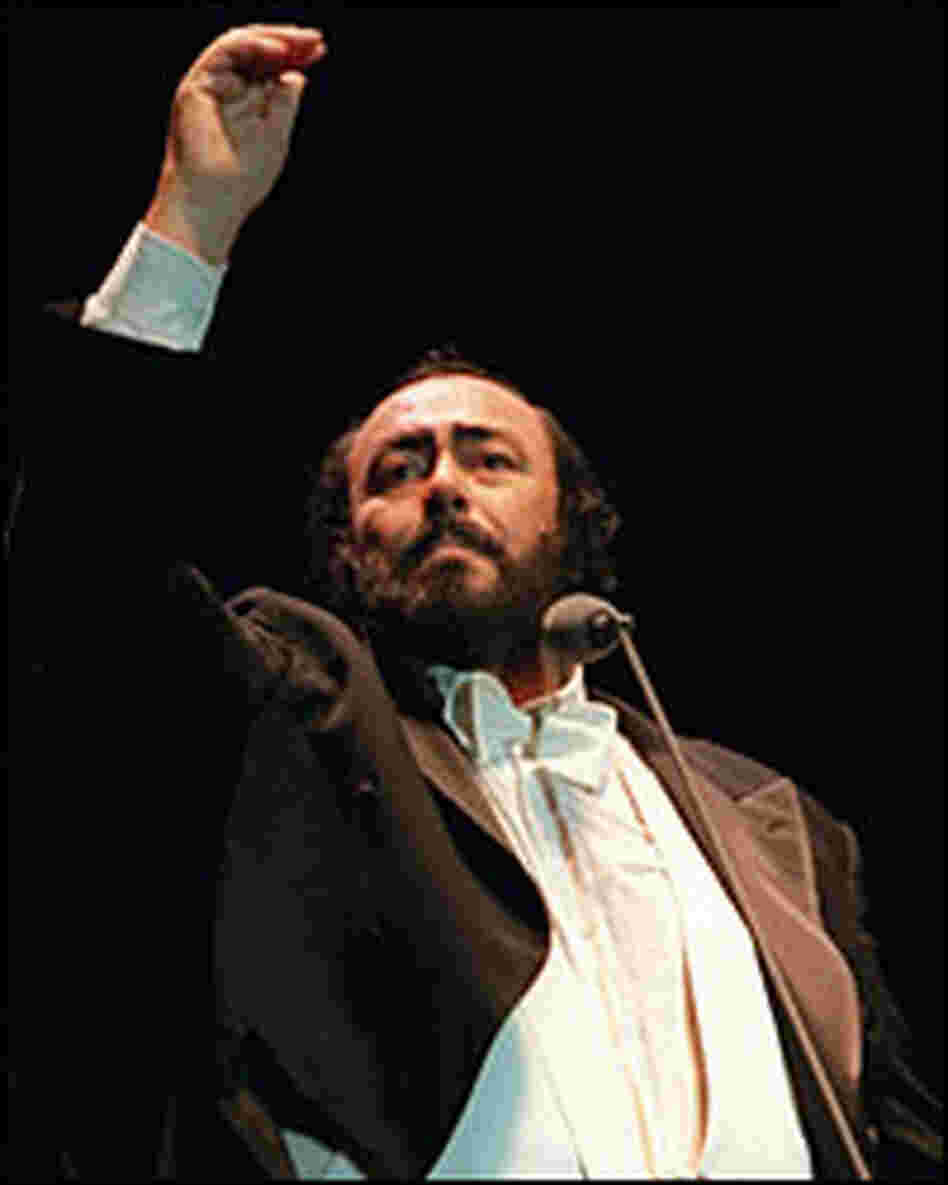Luciano Pavarotti raises his hand to cue the audience in a sing-along encore. Luciano Pavarotti raises his hand to cue the audience in a sing-along encore.