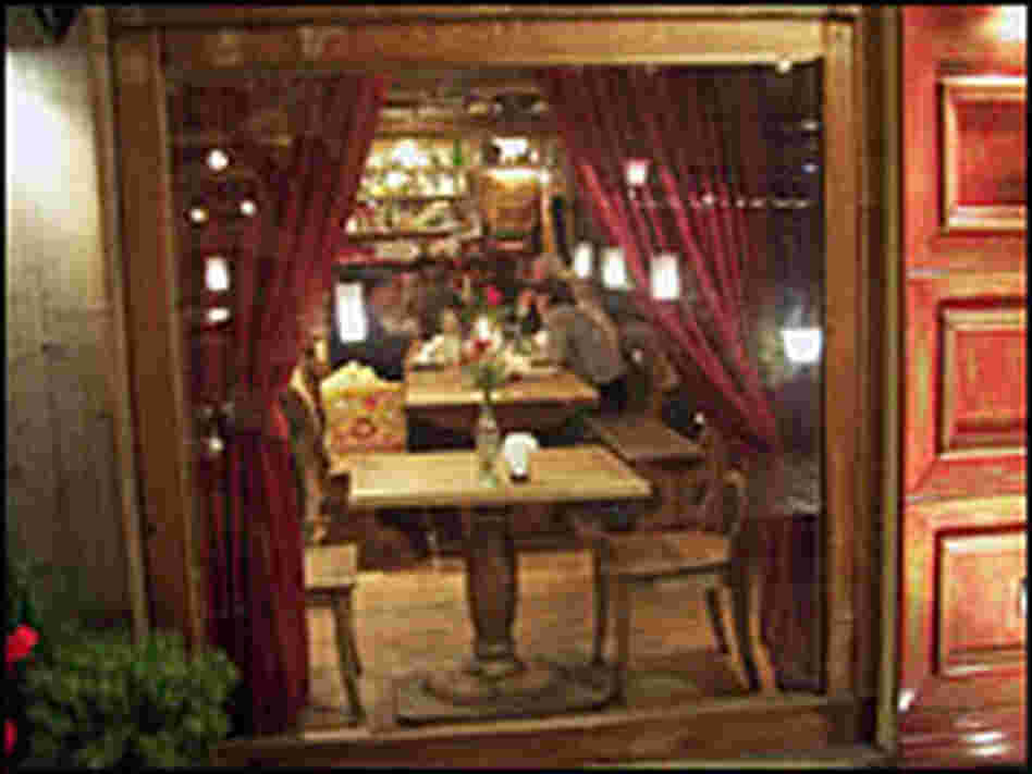 The dining room features long tables and red-cushioned booths.