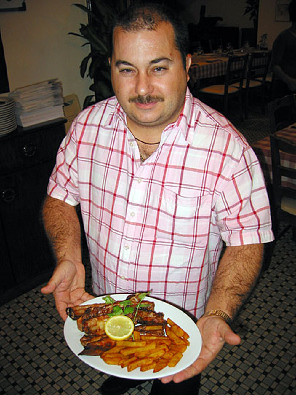 Eusebio Tome is owner of A Petisqueira, a Portuguese restaurant in Macau. He serves a plate of grill
