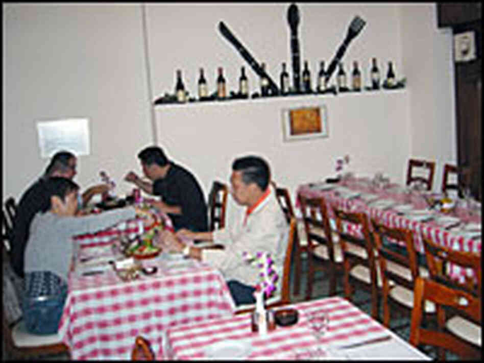 Red-and-white-checked table cloths and wine bottles decorate the homey restaurant.