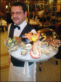 A waiter at Alsatian brasserie Bofinger carries one of the eatery's signature dishes — a platter of <em>fruits de mer</em>, or shellfish. Bofinger is the oldest brasserie, or brewing house, in Paris.