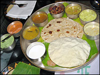 <em>Thali</em> — an array of South Indian dishes served on a banana leaf — is one of the delicious and inexpensive choices at Naivedyam in New Delhi's trendy Haus Khas village.