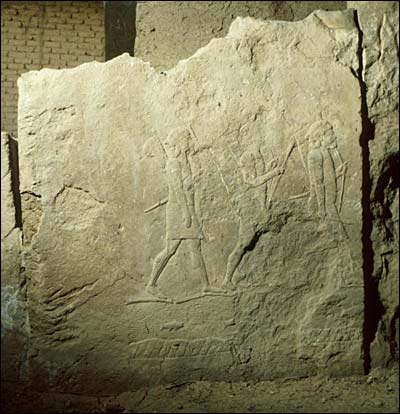 A relief sculpture portraying Assyrian soldiers marching into battle.