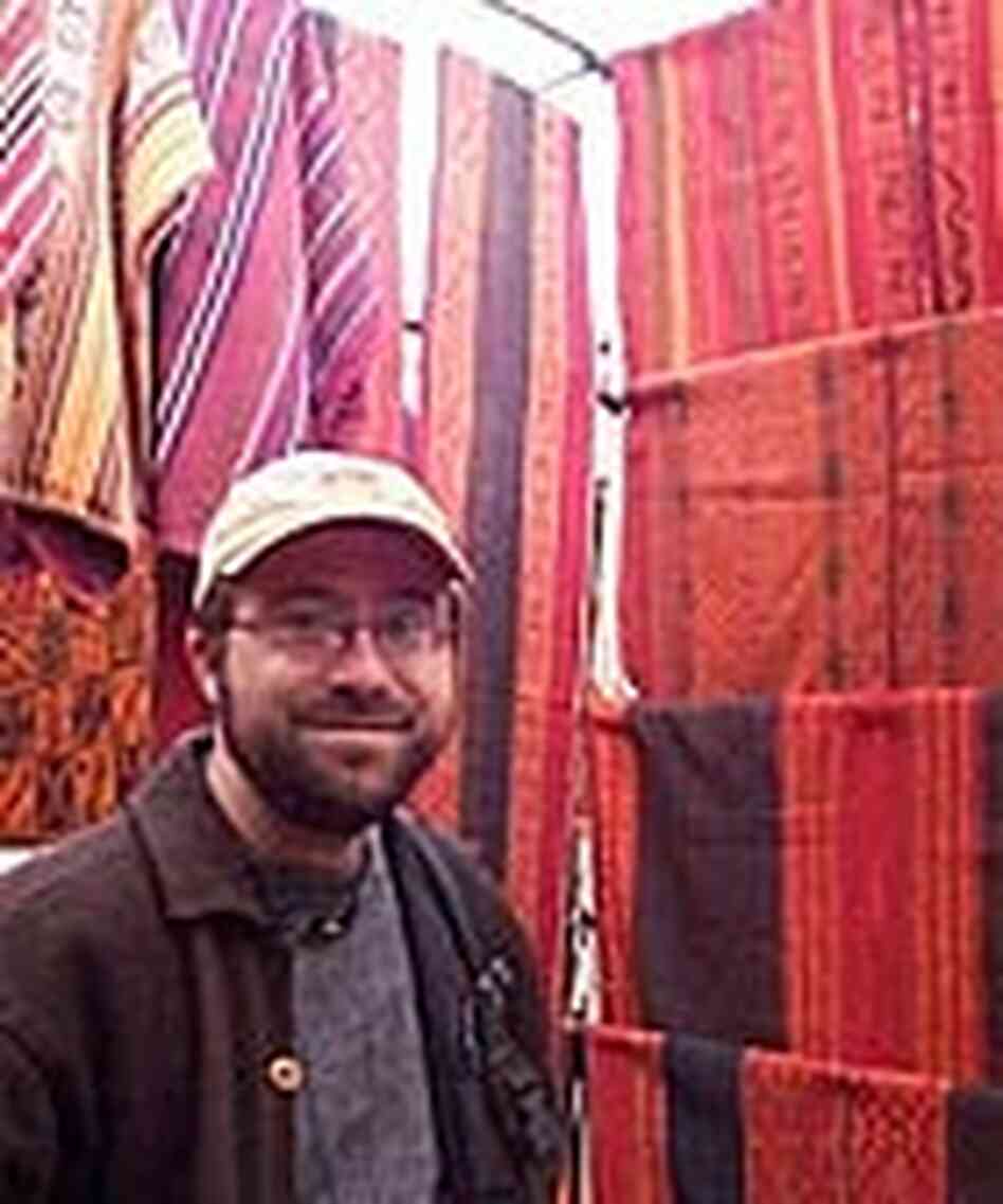 NPR's Martin Kaste with examples of Peruvian textiles colored with dye from the cochineal. NPR's Martin Kaste with examples of Peruvian textiles colored with dye from the cochineal.