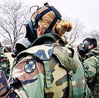 Members of the 85th Medical Division don gas masks.