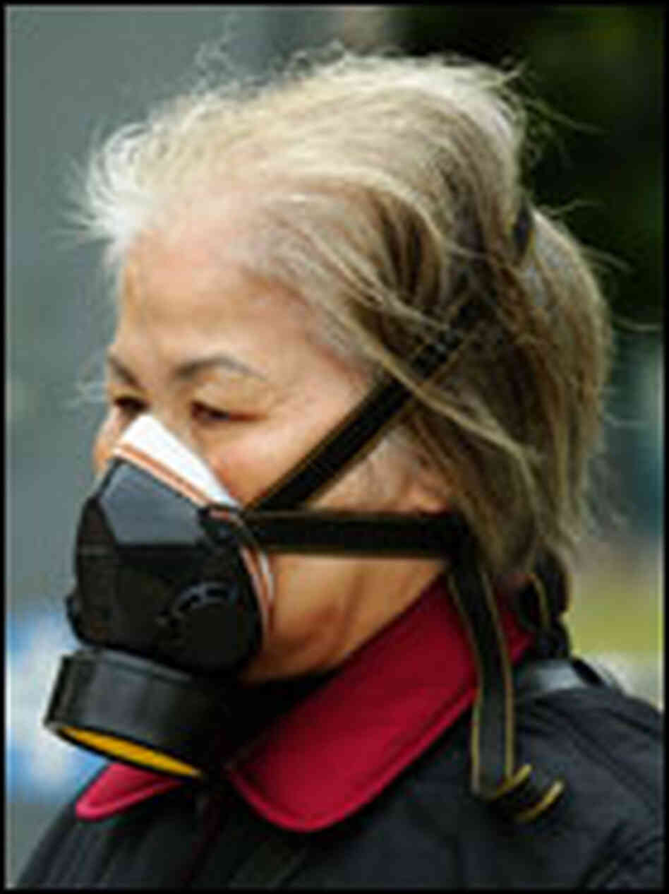 A woman wears a gas mask as she walks outside Hong Kong's Prince of Wales hospital. A woman wears a gas mask as she walks outside Hong Kong's Prince of Wales hospital.