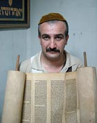 Emad Levy holds a 200-year-old Torah scroll