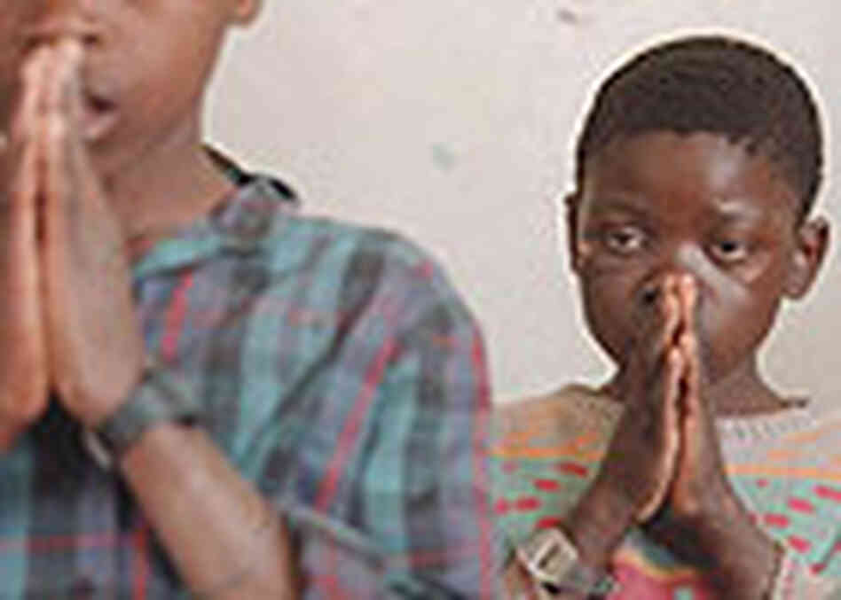 AIDS orphans say a prayer before eating at church in Zambia. AIDS orphans say a prayer before eating at church in Zambia.